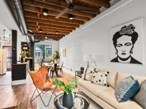 Reclaimed oak planks grounding an eclectic urban loft living room with painted white brick.