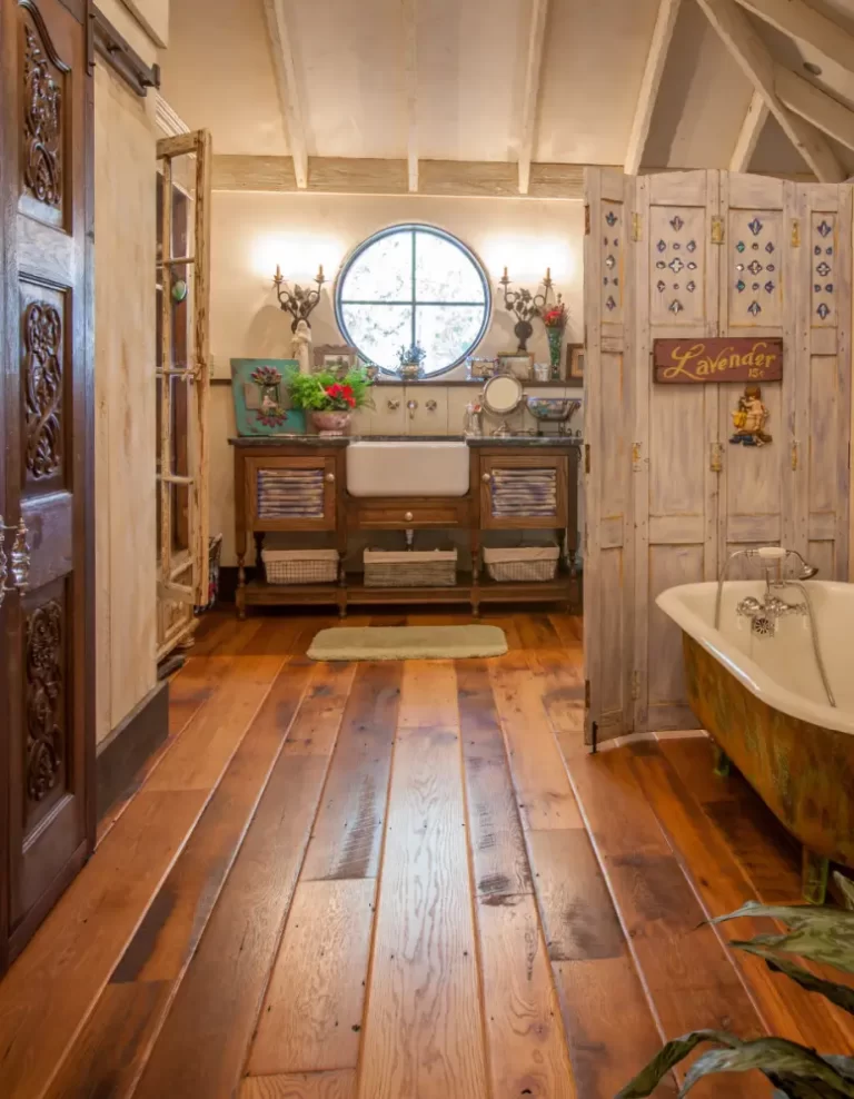 Reclaimed oak wide plank flooring with a worn edge profile in a rustic vintage bathroom.