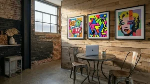A creative office workspace pairing exposed brick with reclaimed oak wall planks. Sunlight streams across the textured wood cladding, highlighting two vibrant pop-art prints above a small meeting table.
