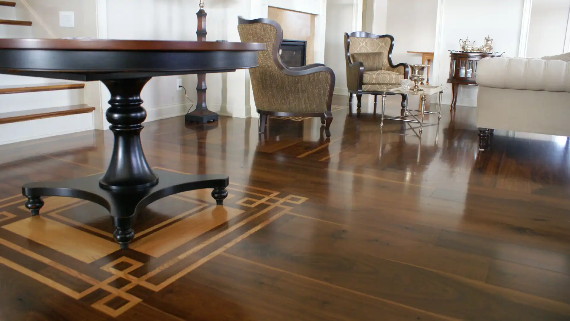 Polished Rustic Walnut flooring displaying a custom-crafted border in a formal sitting room.