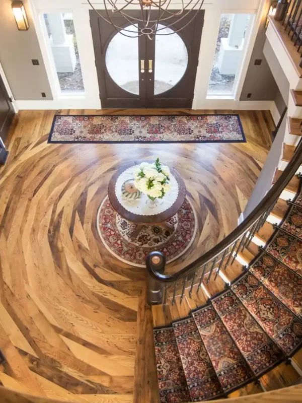 Reclaimed wormy chestnut flooring in a luxury grand foyer featuring a custom concentric circular installation pattern.