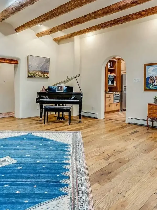 Reclaimed wormy chestnut flooring in a spacious Southwestern living room with a kiva fireplace.