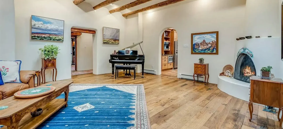 Reclaimed wormy chestnut flooring in a spacious Southwestern living room with a kiva fireplace.