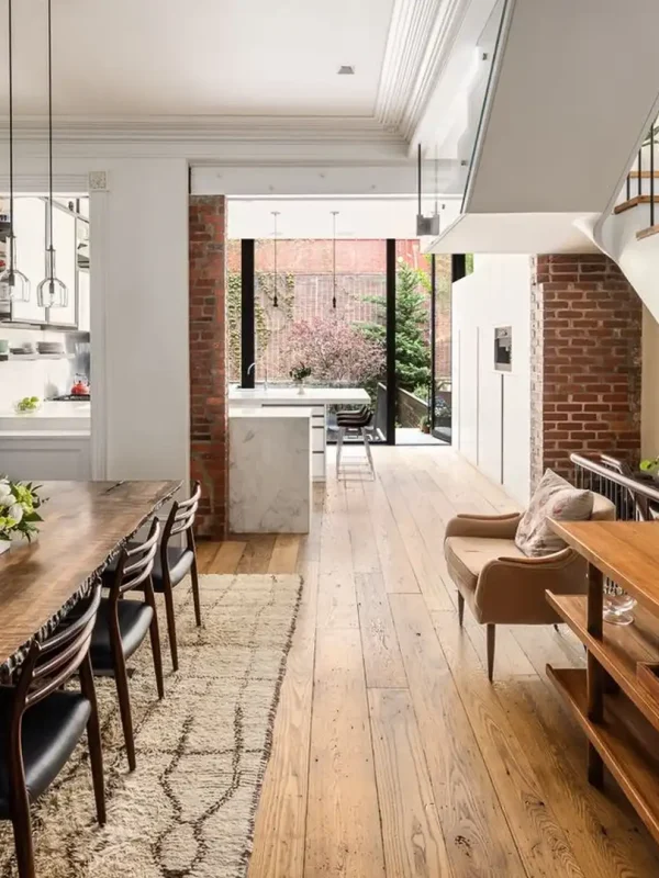 Reclaimed chestnut flooring in a bright, modern historic townhome with an open dining area and exposed brick.