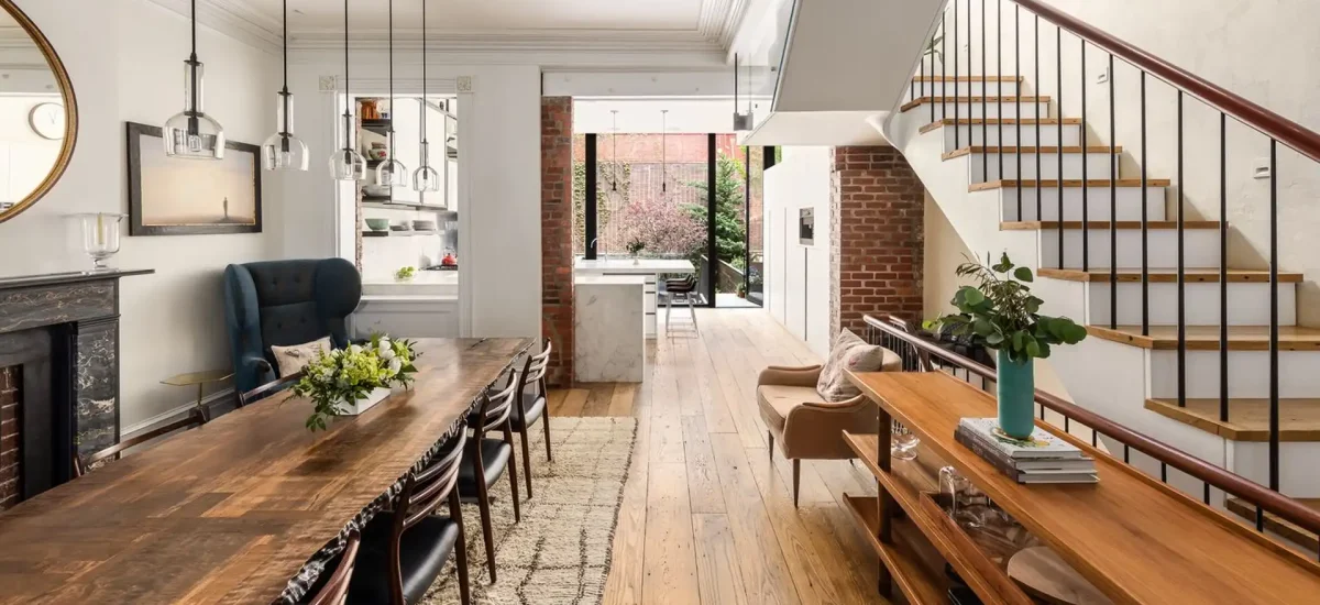 Reclaimed chestnut flooring in a bright, modern historic townhome with an open dining area and exposed brick.