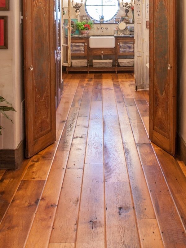 Antique barn board oak with a custom worn edge flowing through a vintage residential hallway.