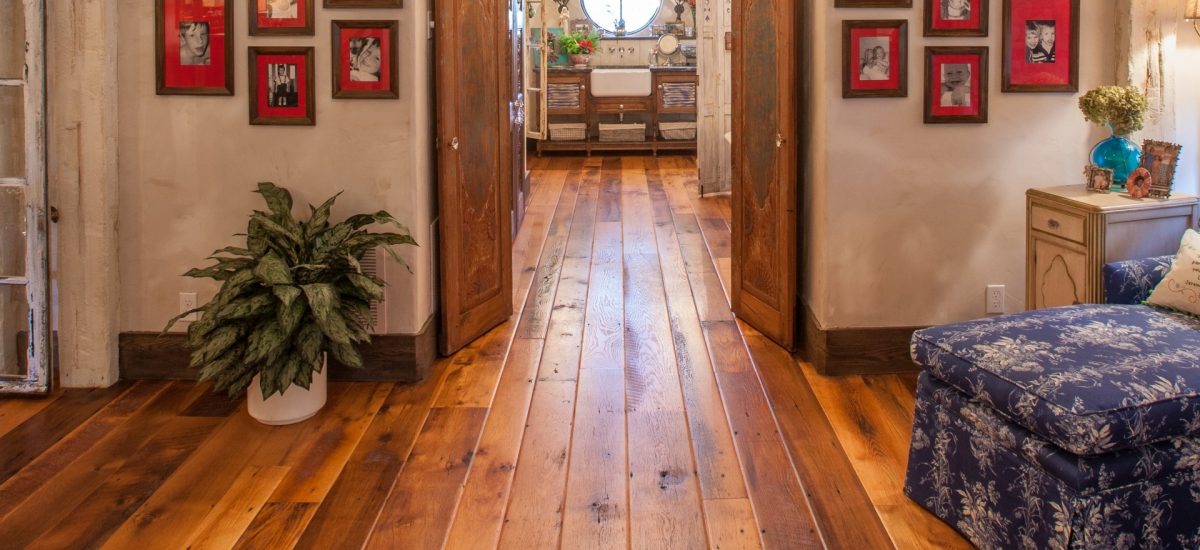 Antique barn board oak with a custom worn edge flowing through a vintage residential hallway.