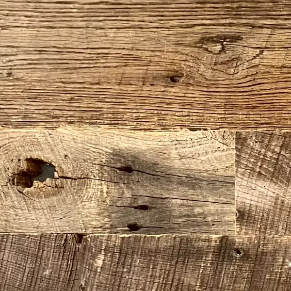 Rustic barnwood wall boards showcasing stable sound knots and original natural voids for an authentic architectural finish.