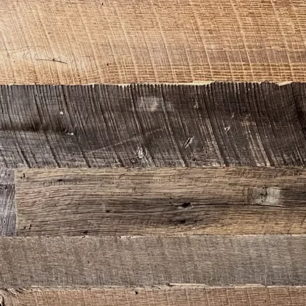 Close-up of Brown Board reclaimed barnwood planks showing original circular saw marks and earthen patina
