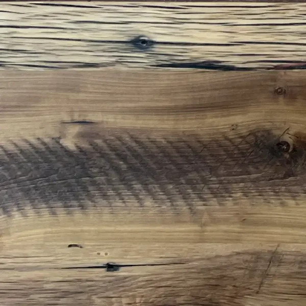Reclaimed barn board flooring showing nail holes and other fastener marks.