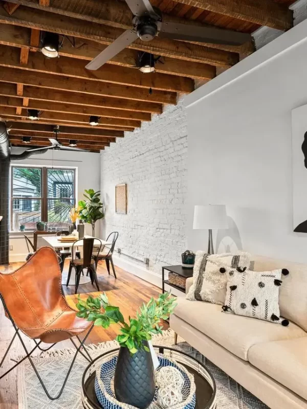Reclaimed oak planks grounding an eclectic urban loft living room with painted white brick.
