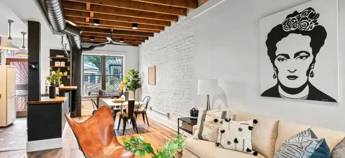 Reclaimed oak planks grounding an eclectic urban loft living room with painted white brick.