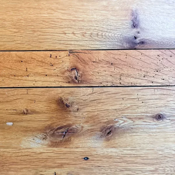 Reclaimed Oak Flooring: Character Defined by Time and Nature This flooring showcases the authentic beauty of reclaimed oak, featuring a rich tapestry of textures and tones. The presence of sound knots and natural voids is not a flaw but a testament to the wood's history, adding depth and visual interest to every plank. These imperfections tell a story of years gone by, transforming each floor into a unique, handcrafted masterpiece.