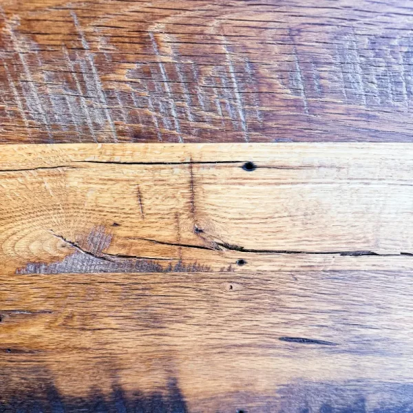 Antique Oak flooring displaying the original skip-planing and distinctive saw marks, highlighting the character of reclaimed lumber.