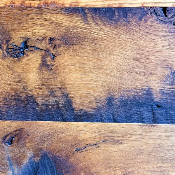 Reclaimed oak flooring displaying the "hit and miss" planing method, balancing fresh wood with the original surface for a unique, reclaimed aesthetic.