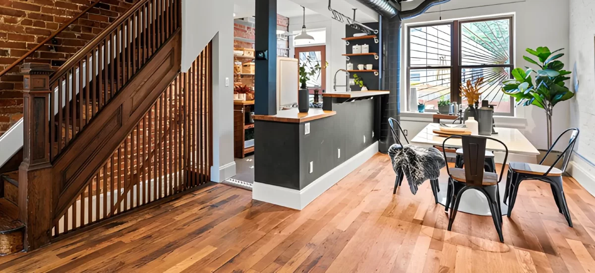 Reclaimed oak flooring complementing exposed brick and metal ductwork in an industrial loft.