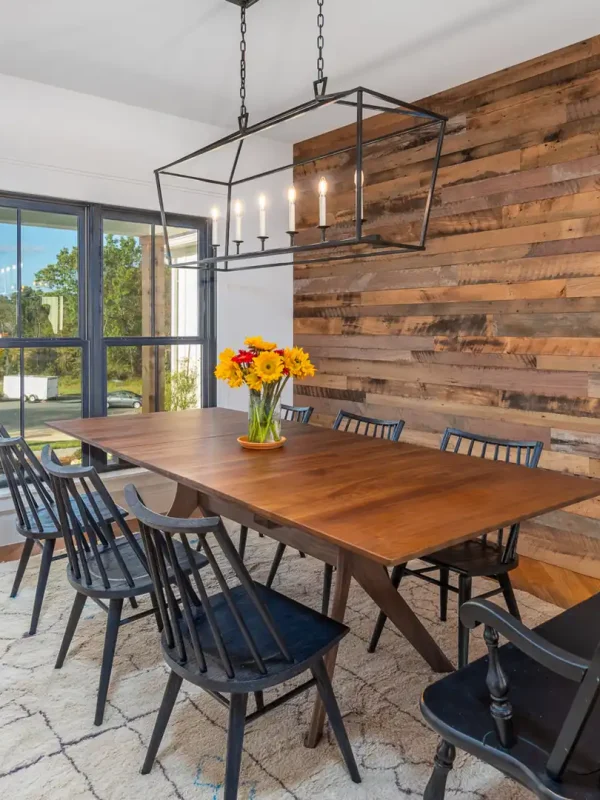 Reclaimed mixed-tone wood cladding serving as a focal wall behind a modern farmhouse dining table.