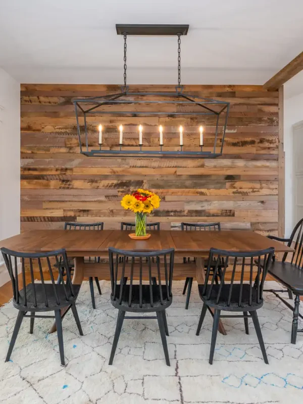 Skip planed reclaimed wood accent wall cladding in a bright modern farmhouse dining room.