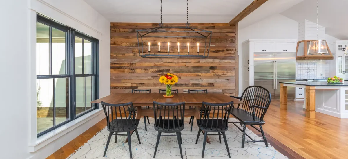 Skip planed reclaimed wood accent wall cladding in a bright modern farmhouse dining room.