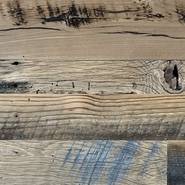 Close-up of skip planed reclaimed wood planks revealing authentic insect scars and worm holes.