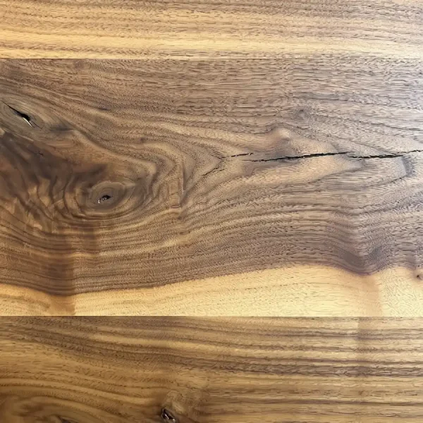 Close-up of Rustic Walnut flooring highlighting authentic stress cracks and rich heartwood grain.