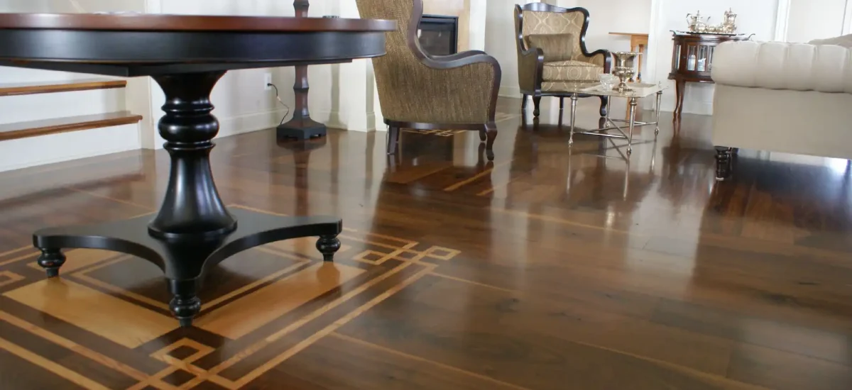 Solid Country Plank Walnut flooring featuring a custom geometric wood inlay in a formal living room.